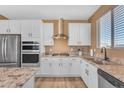 Modern kitchen with white cabinets, stainless steel appliances, and granite countertops at 40657 W Somers Dr, Maricopa, AZ 85138