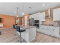 Open concept kitchen featuring island with bar seating and stainless steel appliances at 40657 W Somers Dr, Maricopa, AZ 85138