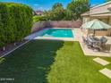 Backyard oasis features a sparkling pool with water features, lush lawn and a dining area at 4236 S John Way, Chandler, AZ 85249