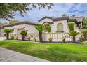 Charming single-story home features a well-manicured lawn, complemented by a decorative fence and lush landscaping at 4711 E Buckboard Ct, Gilbert, AZ 85297