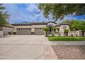 Spacious home featuring a three-car garage and beautifully landscaped front yard with mature trees at 4711 E Buckboard Ct, Gilbert, AZ 85297