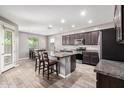 Spacious kitchen featuring a granite-topped island, stainless appliances, and tile flooring with a dining area at 5519 N 187Th Ln, Litchfield Park, AZ 85340