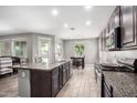 Open-concept kitchen featuring an island with a sink, granite counters, stainless appliances and seamless access to dining at 5519 N 187Th Ln, Litchfield Park, AZ 85340