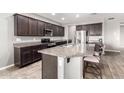Well-lit kitchen boasts granite countertops, stainless steel appliances, and a functional island with bar seating at 5519 N 187Th Ln, Litchfield Park, AZ 85340