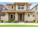 Inviting two-story home featuring a cozy front porch, complemented by a well-maintained lawn and desert landscaping at 5840 E Holmes Ave, Mesa, AZ 85206