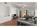 Cozy living room boasts tile floors, a ceiling fan, and abundant natural light from the backyard sliding glass door at 684 E Redondo Dr, Gilbert, AZ 85296