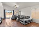 Bright living room with ceramic tile floors, ceiling fan, and a sliding glass door for easy patio access at 684 E Redondo Dr, Gilbert, AZ 85296