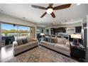 Open-concept living room with modern furnishings, ceiling fan, and sliding glass doors to the backyard at 7432 W Bronco Trl, Peoria, AZ 85383
