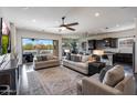 Open-concept living room with modern furnishings, ceiling fan, and sliding glass doors to the backyard at 7432 W Bronco Trl, Peoria, AZ 85383