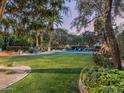 Expansive backyard with lush lawn, mature trees, and a sparkling pool, perfect for outdoor entertaining at 8022 N Ironwood Dr, Paradise Valley, AZ 85253