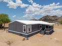 Exterior view of home with gray paint, white trim, and mountain views in the background at 11192 N Johnson Rd, Maricopa, AZ 85139
