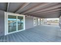 Covered patio features gray carpet, views, and access to the home through sliding glass doors at 11192 N Johnson Rd, Maricopa, AZ 85139