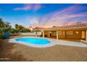 Outdoor pool with stone patio, desert landscaping, and covered patio area with seating at 12448 N 76Th St, Scottsdale, AZ 85260