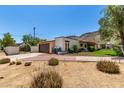 View of home with large garage, red brick accents, and well-maintained desert landscaping at 12835 N 16Th Dr, Phoenix, AZ 85029