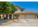 Inviting two-story home with a two-car garage, desert landscaping, and charming front porch at 12950 W Alegre Dr, Litchfield Park, AZ 85340