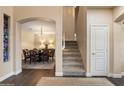 Charming entryway with staircase, wood flooring, and adjacent dining room with a chandelier and seating for eight at 13634 W San Miguel Ave, Litchfield Park, AZ 85340