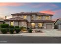 Beautiful two-story home boasts a neutral color, tile roof, well-maintained lawn, and attached two-car garage at 13634 W San Miguel Ave, Litchfield Park, AZ 85340