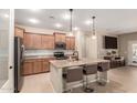 Modern kitchen with stainless steel appliances, granite countertops, a center island, and stylish pendant lighting at 1410 W Popcorn Tree Ave, Queen Creek, AZ 85140