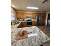 Bright kitchen with granite counters, stainless appliances, wood cabinets, and breakfast bar island at 1616 W Temple St, Chandler, AZ 85224