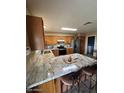 Spacious kitchen with granite countertops, wood cabinets, stainless appliances, and breakfast bar seating at 1616 W Temple St, Chandler, AZ 85224