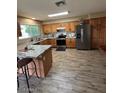 Traditional kitchen featuring granite countertops, wood cabinets, stainless steel appliances, and wood plank flooring at 1616 W Temple St, Chandler, AZ 85224
