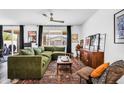 Bright and airy living room features an L-shaped sofa, neutral walls, and a sliding glass door leading to the patio at 1747 E Grove St, Phoenix, AZ 85040