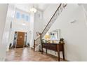 Bright foyer featuring high ceilings, tiled floors, a wooden door, and a staircase with iron railings at 18329 W Montebello Ave, Litchfield Park, AZ 85340