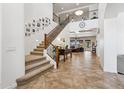 Inviting foyer with soaring ceilings, tile flooring, staircase, and views into the living room at 18329 W Montebello Ave, Litchfield Park, AZ 85340