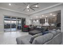 Spacious living room featuring a large ceiling fan and sliding glass doors to the patio at 18493 W Hiddenview Dr, Goodyear, AZ 85338