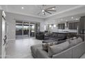 Spacious living room with tile floors, fan, and sliding doors to the covered patio at 18493 W Hiddenview Dr, Goodyear, AZ 85338