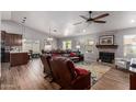 Spacious living room with a fireplace, wood floors, modern furniture, and an open layout to the dining area at 19 W Wickieup Ln, Phoenix, AZ 85027