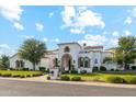 Stunning stucco home with manicured lawn and beautiful architectural details under a bright blue sky at 2748 E Warbler Rd, Gilbert, AZ 85297
