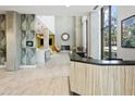 Modern lobby featuring light wood floors, concrete columns, and a reception desk with views to a cozy lounge area at 3131 N Central Ave # 3009, Phoenix, AZ 85012