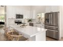 Stylish kitchen with white cabinetry, stainless steel appliances, and a spacious quartz countertop island at 325 N Redrock St, Gilbert, AZ 85234