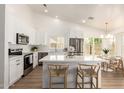 Modern kitchen with white cabinets, stainless steel appliances, and a large island with bar seating at 325 N Redrock St, Gilbert, AZ 85234