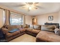 Relaxing living room featuring a sectional sofa, ceiling fan, and natural light at 3410 W Pershing Ave, Phoenix, AZ 85029