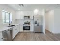 Bright kitchen featuring stainless steel appliances, white cabinets, and a tiled backsplash at 3609 E Palm Ln, Phoenix, AZ 85008