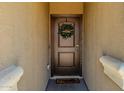 Inviting entryway featuring a solid wood door with decorative wreath and a 'Welcome' mat at 36412 W Pampoloma Ave, Maricopa, AZ 85138