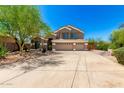 Charming front exterior with desert landscaping, mature trees, and a wide driveway at 4801 E Quien Sabe Way, Cave Creek, AZ 85331