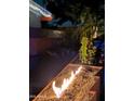 Backyard with an outdoor built-in gas fire feature set with a cactus and gravel at 5739 N 11Th St, Phoenix, AZ 85014
