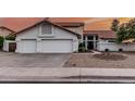 Attractive home with a tile roof, three-car garage, and desert landscaping at 6133 E Saddleback St, Mesa, AZ 85215