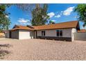 Charming single-story home featuring a gray brick garage and low maintenance rock landscaping at 6751 W Cameron Dr, Peoria, AZ 85345