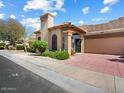 Charming home featuring a well-maintained front yard and a paved driveway leading to an attached garage at 7955 E Chaparral Rd # 115, Scottsdale, AZ 85250