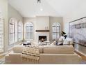 Elegant living room with a cozy fireplace and stylish seating arrangement, framed by shuttered windows and artwork at 7955 E Chaparral Rd # 115, Scottsdale, AZ 85250