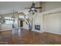 Open living room featuring fireplace, vaulted ceilings, staircase and stained concrete flooring at 823 W Bradford Dr, Gilbert, AZ 85233