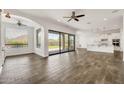Spacious living room with wood-look tile and sliding glass doors to backyard at 9017 E June Cir, Mesa, AZ 85207