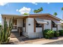Charming mobile home featuring a covered porch, decorative landscaping, and desert flora at 9501 E Broadway Rd # 168, Mesa, AZ 85208