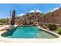Backyard pool surrounded by desert landscaping and mountain views, ideal for relaxation and outdoor entertaining at 14058 S 24Th Way, Phoenix, AZ 85048