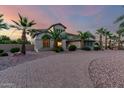 Beautiful home featuring desert landscaping, a circular brick driveway, and mature palm trees at 14494 W Yucatan St, Surprise, AZ 85379