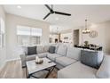 Spacious living room featuring a comfortable, oversized couch and a view into the kitchen at 1865 N 141St Ave, Goodyear, AZ 85395